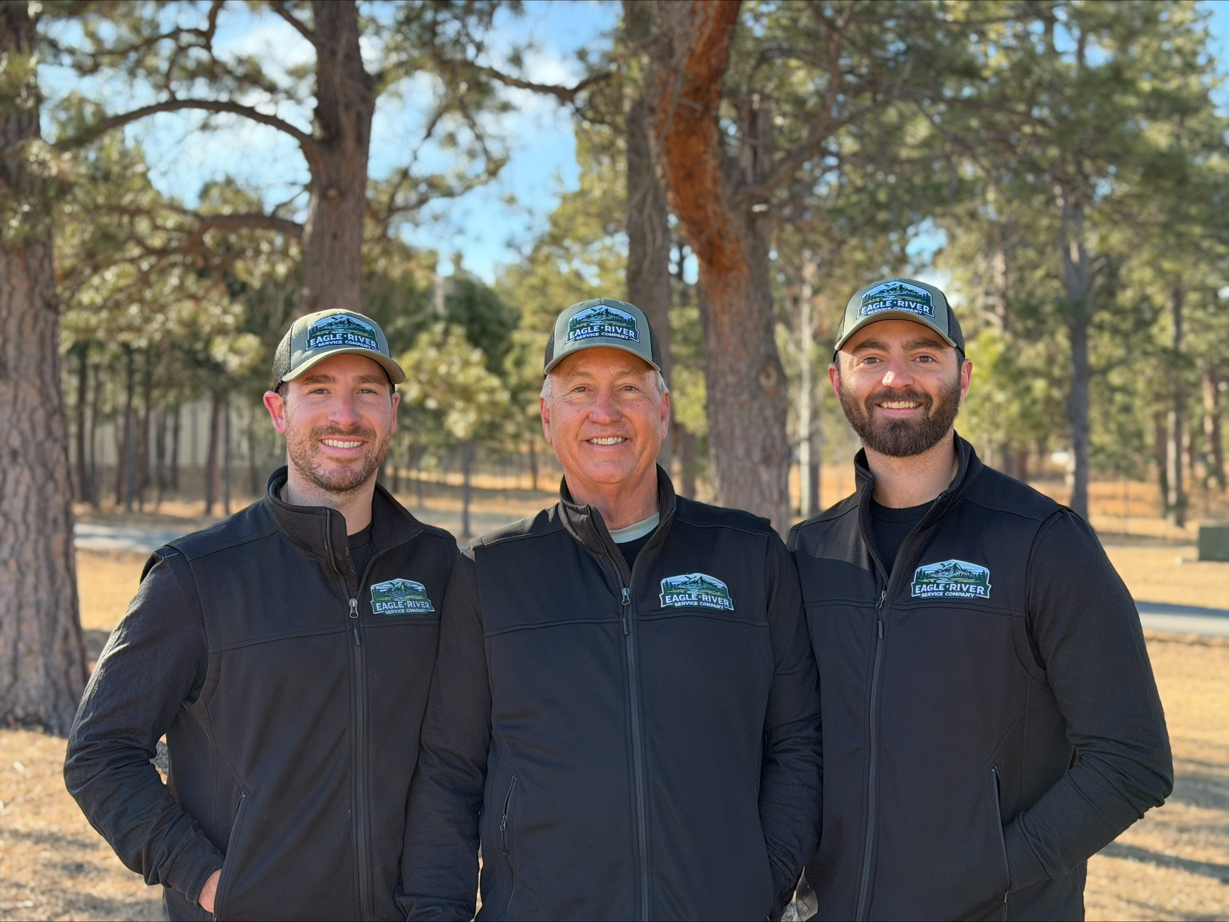 Three HVAC technicians standing together outside