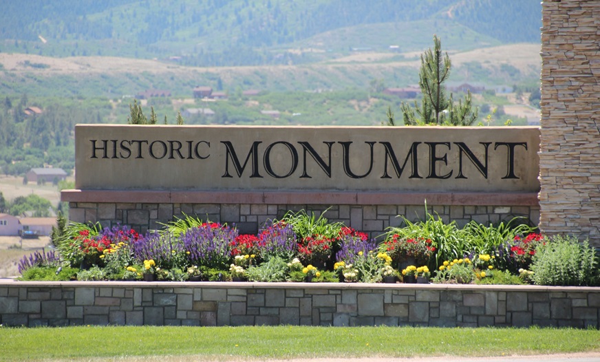photo of mounument colorado sign with flowers around it