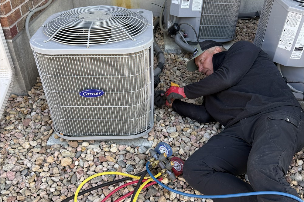 Technician repairing an air conditioning unit in parker