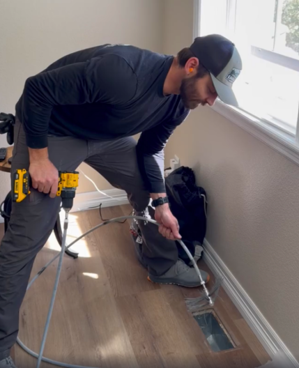 Man cleaning an air duct with a high speead brush