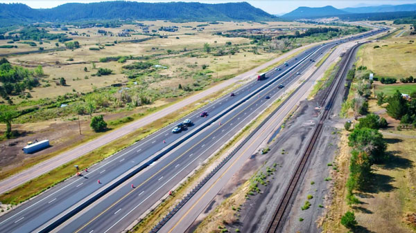 highway surrounded by open space and foothills