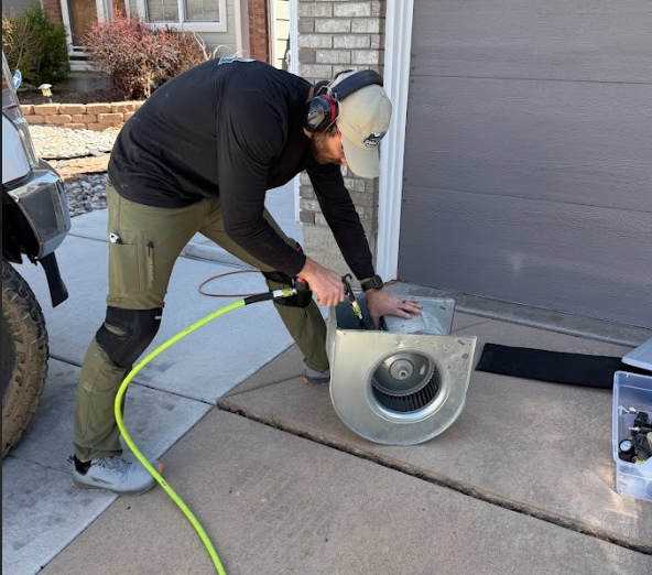 man cleaning HVAC components